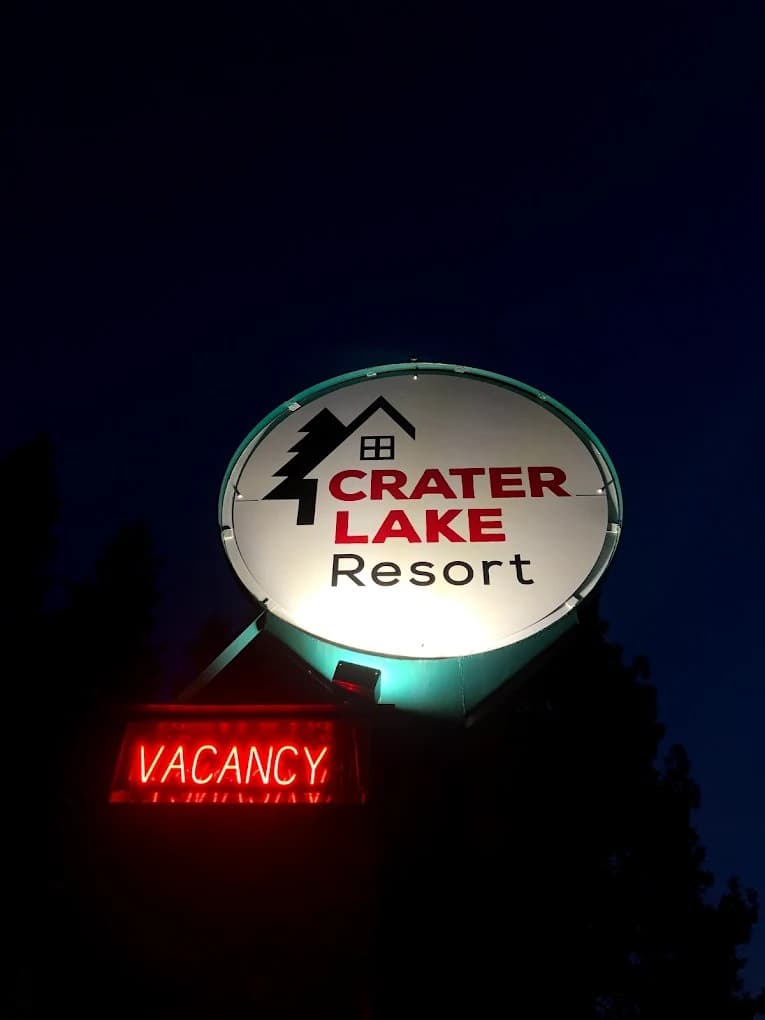 Lit Crater Lake Resort sign at night with vacancy indicator