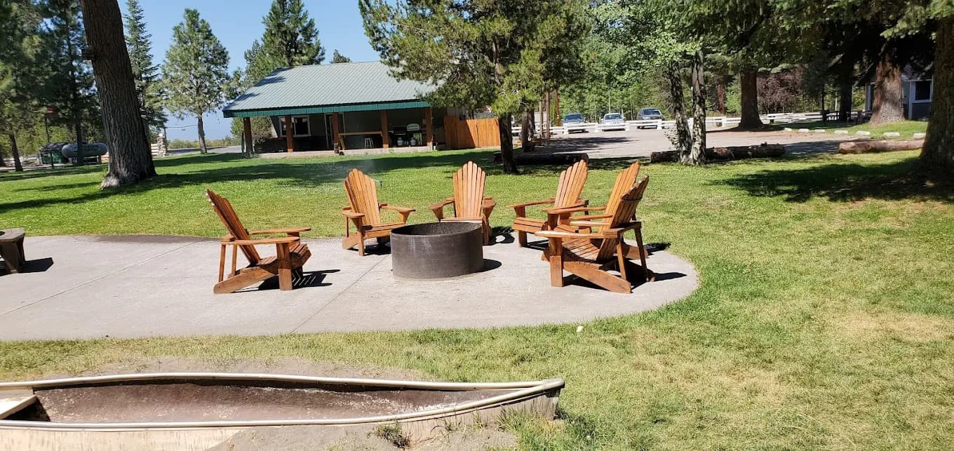 Circle of Adirondack chairs around a community fire pit on the lawn