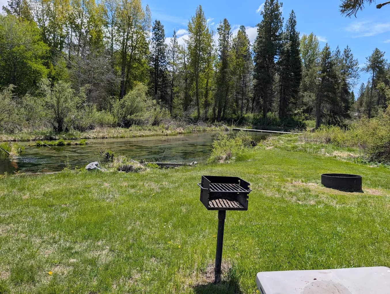 Creekside tent site with BBQ grill, fire ring, and Fort Creek view at Crater Lake Resort