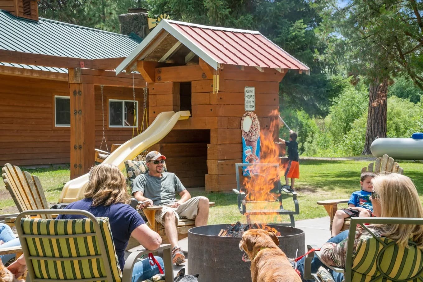 Community fire pit at the resort with chairs, a playhouse, and friends gathered