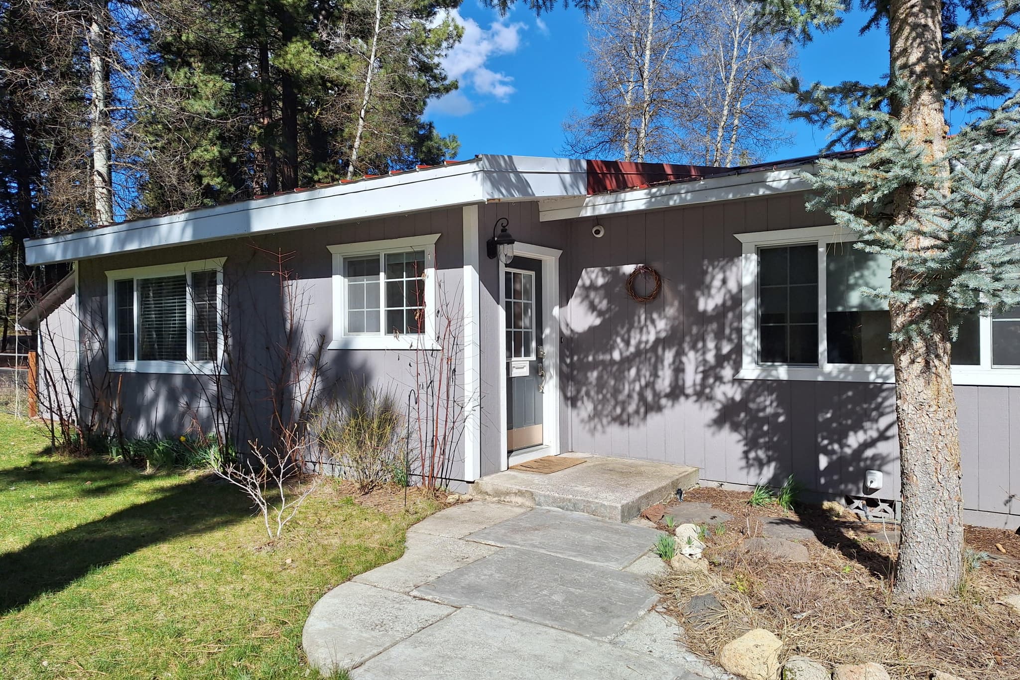 Vacation home exterior — gray siding with metal roof accent