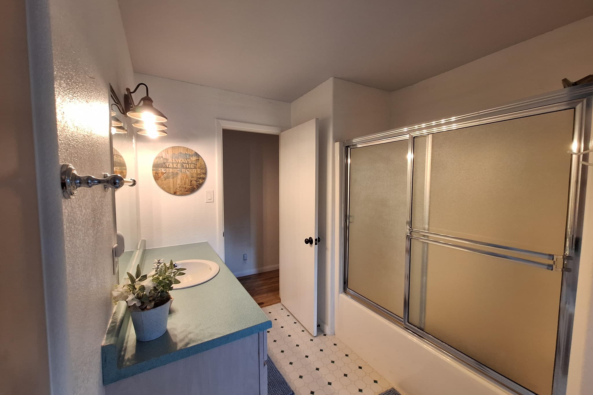 Guest bathroom with tub-shower combo and sconce lighting